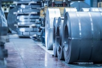 Industrial background. Big size steel coil stored inside industrial warehouse, blue toned image