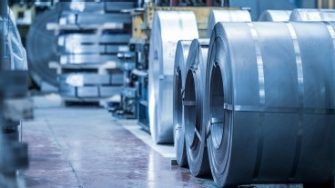 Industrial background. Big size steel coil stored inside industrial warehouse, blue toned image