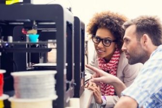 Male and female student looking at 3d printer