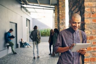 male student leaning against wall