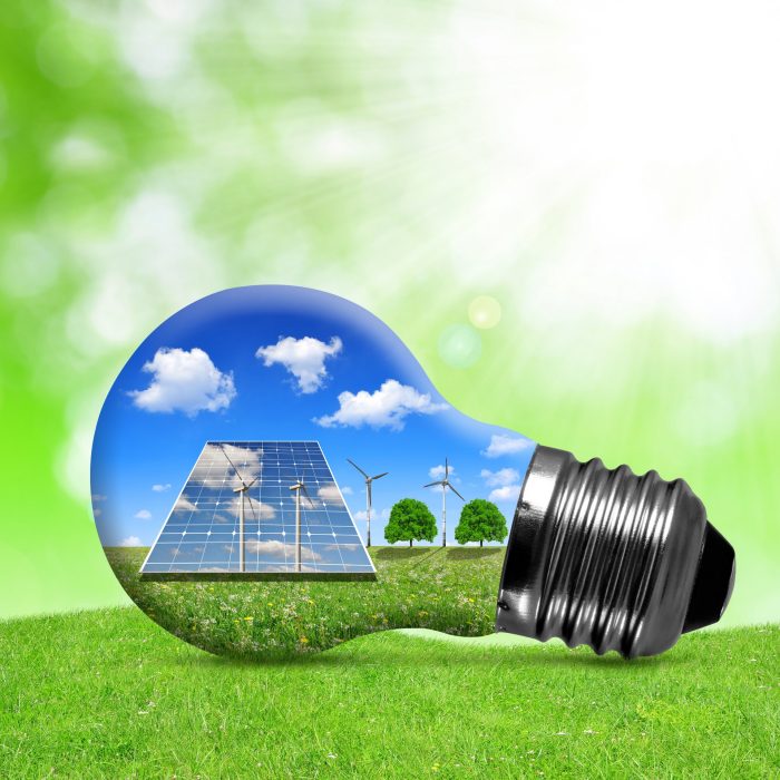 Solar panels and wind turbines in light bulb. Green energy concept.