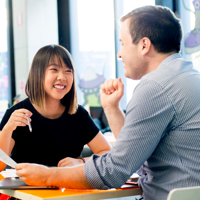 Photograph of a conversation between two adults discussing the disability inclusion plan