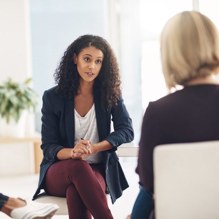 Shot of a young therapist speaking to a couple during a counseling session