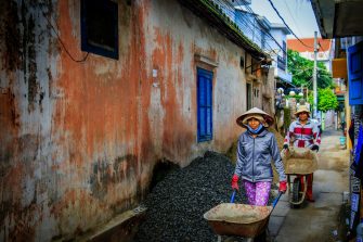 ladies using wheelbarrow to transport goods