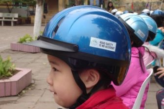 A group of young girls are wearing helmets that say 'Road safety is no accident'