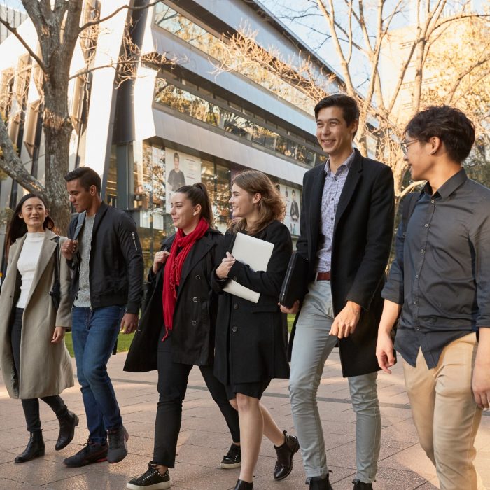 Group of Law students walking on Main Wallkway in front of the Law Building, dressed in smart attire and winter coats