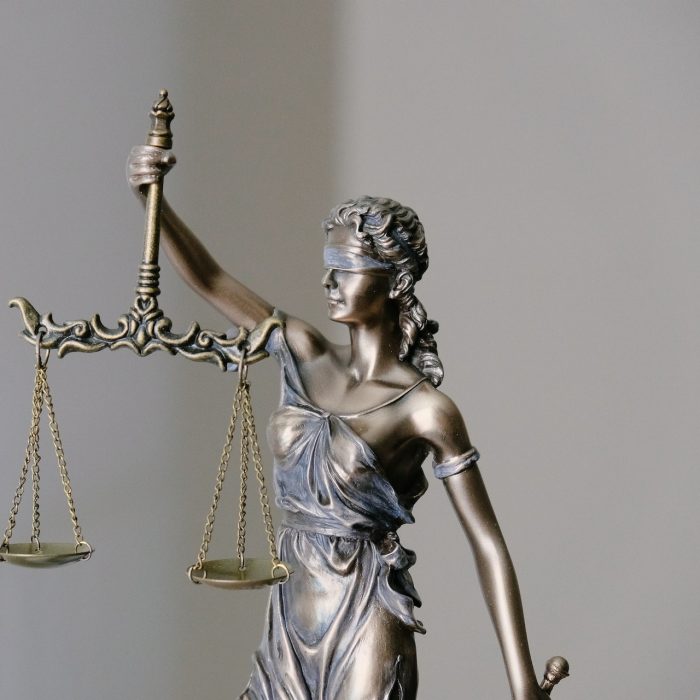 Woman in dress holding sword figurine