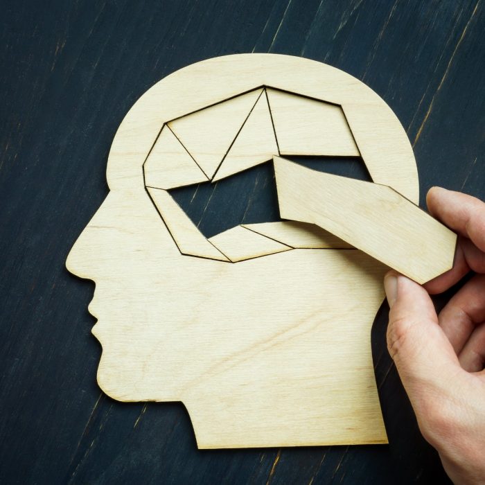 Memory loss and problems with brain. The hand puts the last piece of the puzzle.