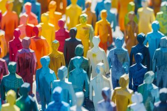 Colorful wooden figurines represent societal diversity, ideal for inclusion campaigns and community events.