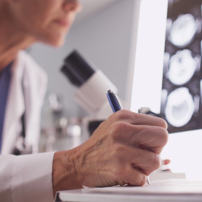 Intelligent female radiologist analyzing with microscope