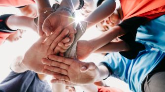 Low angle view of kids putting hands together in circle