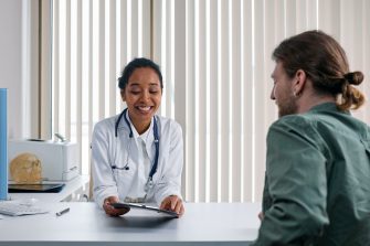 Young doctor sitting with patient