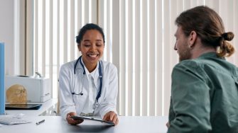 Young doctor sitting with patient