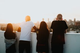 Four people looking at the city at sunset