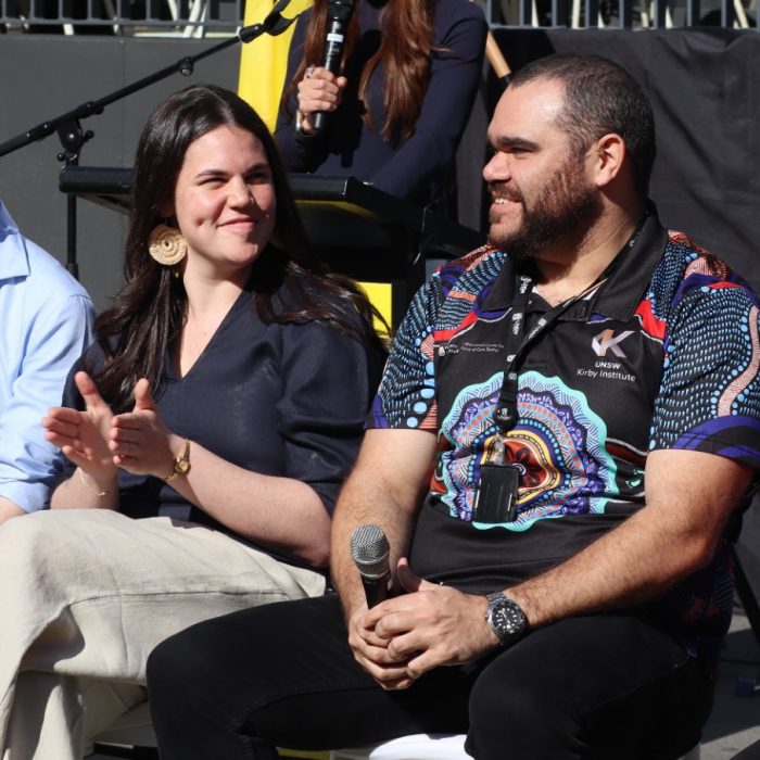 A panel of Indigenous Australians, sitting in a row holding microphones.
