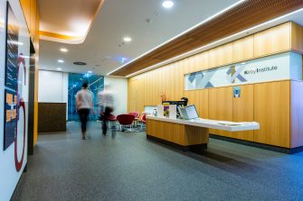 View of the Kirby Institute reception area with two blurry people walking through towards the labs