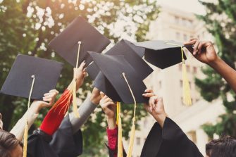Mortarboards being held in air by graduates