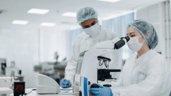Two scientists working at a microscope