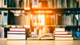 Book stack is placed on the library desk. education background, back to school concept.