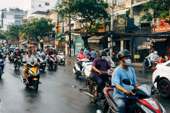 Scooter riders on city street in Vietnam
