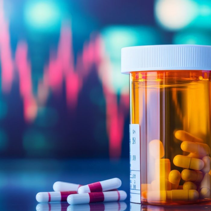 Close-up of a prescription bottle next to a growing stock market chart, pharmaceutical business success.