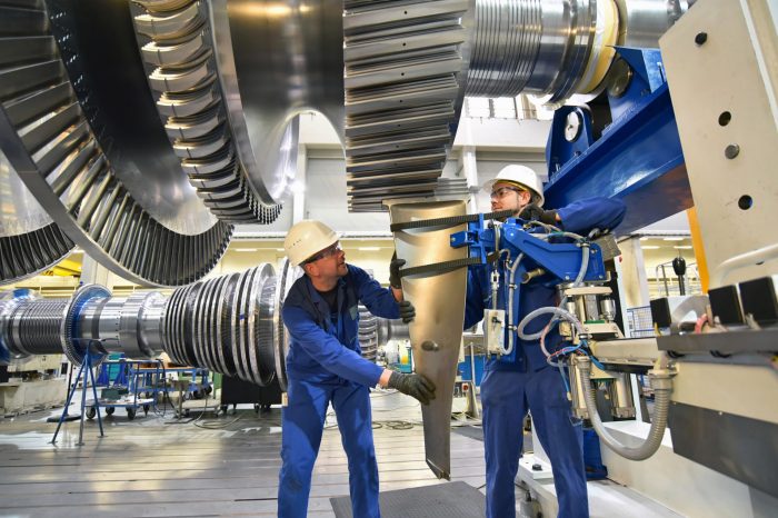 workers assembling gas turbine under giant sprocket adjusted for use as research case study header