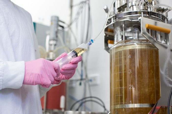 RPF laboratory detail photo of someone adding liquid to a fermenter tank