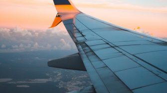 wing of plane in flight with sunset