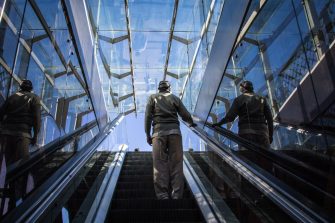 Man standing on an escalator during daytime