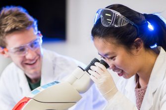 Biotechnology students working with a microscope