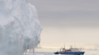 Iceberg in foreground with ship in background