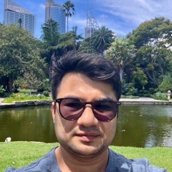 man standing in front of a pond in botanical gardens sydney 