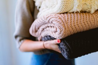 Young woman holding folded laundry