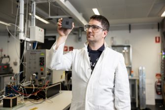 Dr Quentin Meyer in the hydrogen fuel cell laboratory in UNSW, with fuel cell tester in the background