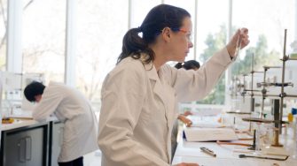 Student looking at a test tube in the lab