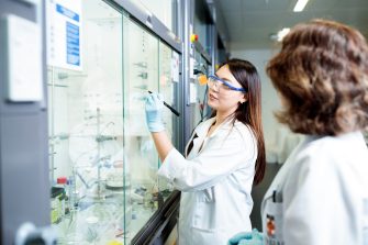 Chemistry student writing on fume cupboard hood