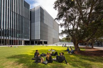 Students sitting on the lawn outside the Science & Engineering Building
