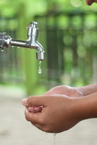 Hands catching water from a dripping tap