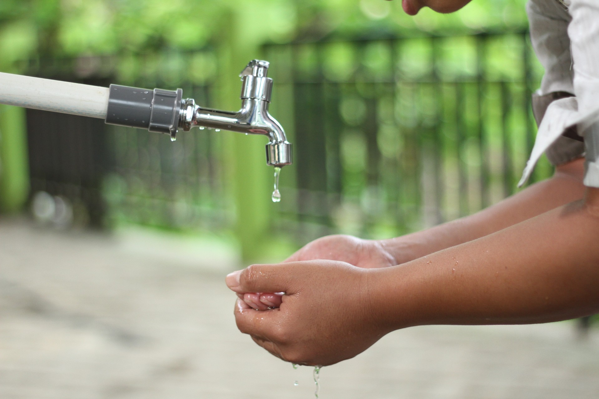 Hands catching water from a dripping tap