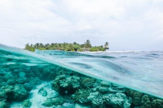 View of ocean above and below with and island in the background