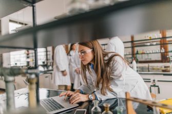 Female chemist using computer in chemical laboratory