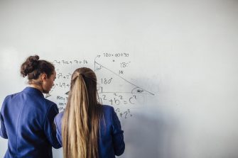 Girls doing maths on whiteboard