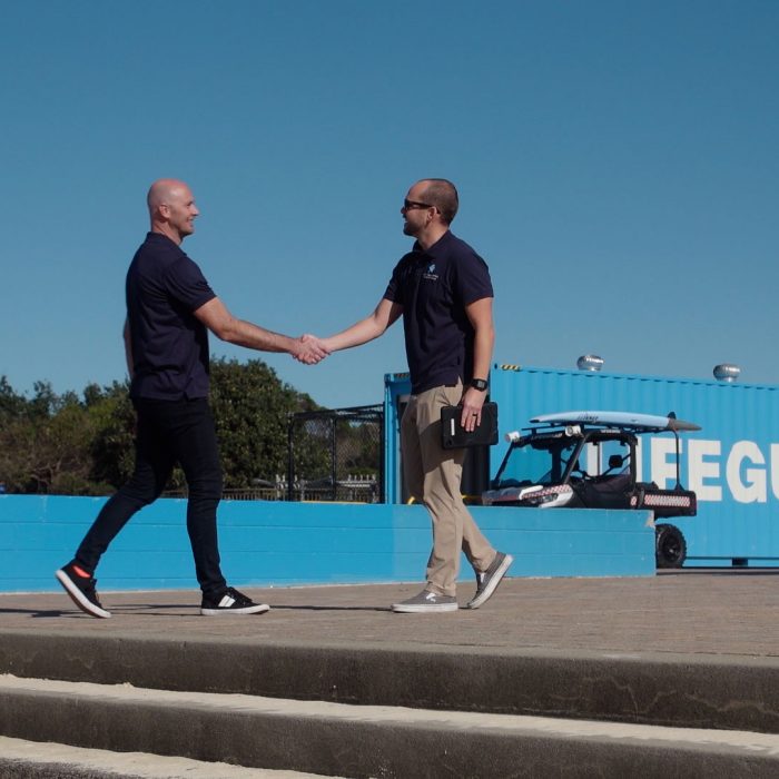 Two males shaking hands outdoors