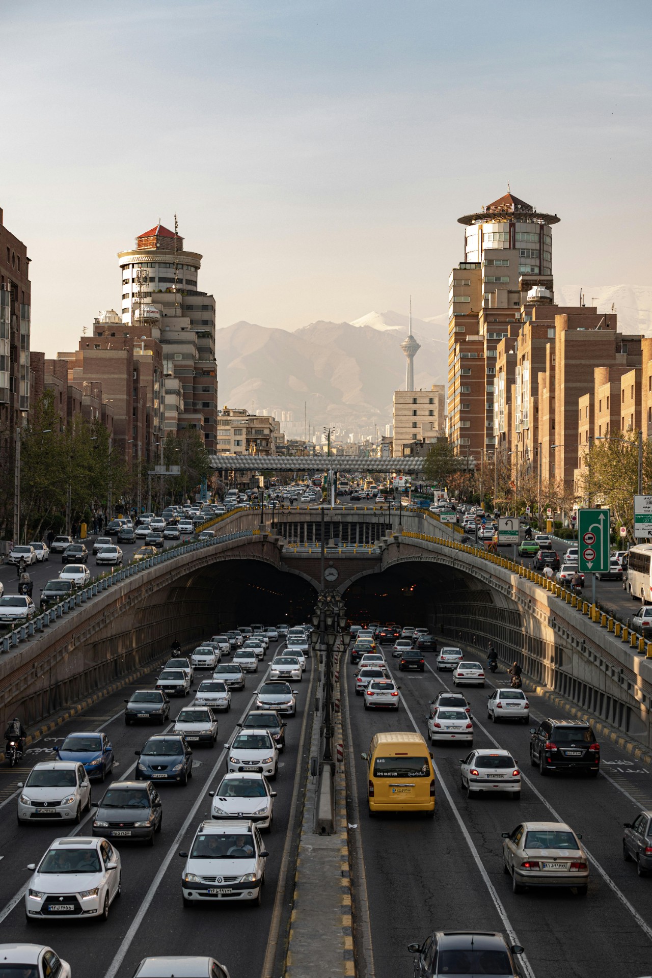 Heavy traffic on a busy street in Tehran, Iran, with the iconic Milad Tower in the background. 