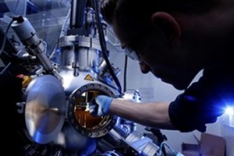 Scientist inserting material into machine