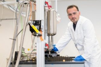 scientist in front of cylinder machine in the lab