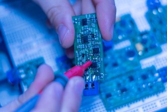engineer hold circuit or silicon chip in his workplace