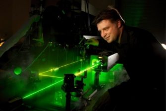 Clemens Ulrich standing infront of a green laser