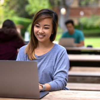 Attractive female asian american cheerful, working remotely from laptop computer at park