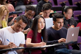 Students with laptops in lecture theatre class